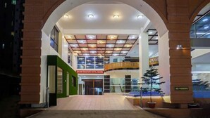 A hotel entrance with a modern design, featuring a large arched entrance, multiple floors, and a "NO PARKING" sign. - Grand Mostafa Hotel Ababil (Sylhet)