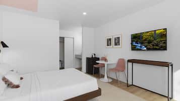A modern hotel room with a bed, a desk, a chair, a TV, and a painting on the wall.