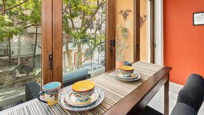 A dining area with a wooden table, two colorful ceramic cups, and a view of a tree through a glass door. - Beautiful condo in the heart of Zona Romantica and steps to Los Muertos Beach! 1 (Puerto Vallarta)