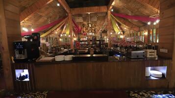 A rustic interior with wooden beams, a bar area, and a large chandelier.