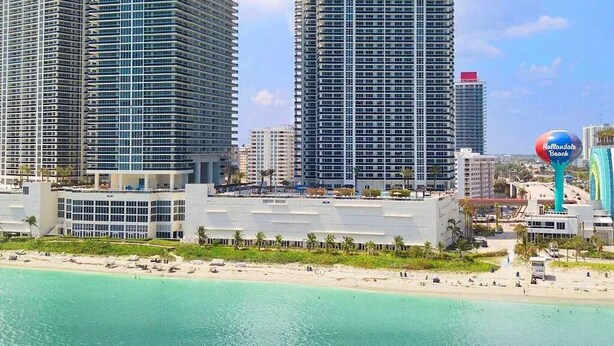 Eine Küstenstadt mit Hochhäusern, einem Strand und einem Schild für Hialeah Beach.