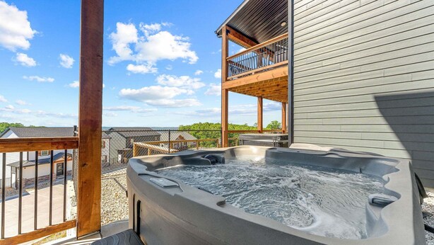 Un bain à remous sur une terrasse, avec vue sur un immeuble et un ciel dégagé.