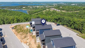 Un quartier résidentiel comprenant plusieurs maisons, une piscine et offrant une vue sur un lac et une forêt.