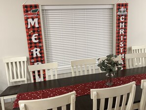 A dining area with a black table, white chairs, and red and black checkered Christmas decorations. - Near Silver Dollar City with Private Hot Tub, Game Area, Community Indoor Pool & Free Daily Tickets (Branson)