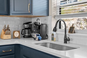 A kitchen with a sink, coffee maker, and utensils. - Near Silver Dollar City with Private Hot Tub, Game Area, Community Indoor Pool & Free Daily Tickets (Branson)