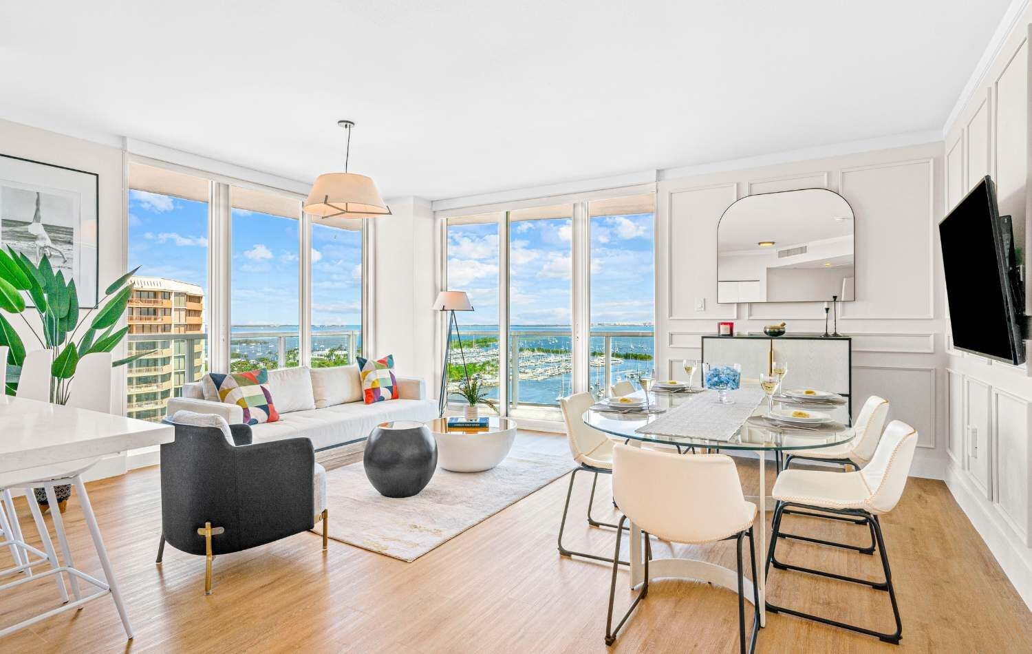 A spacious living area with a dining table, seating, and a view of the sea.