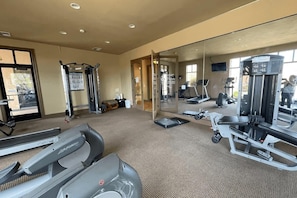 A gym with treadmills, a squat rack, and a weight bench. - Ground Floor Suite | Private Balcony, Poolside Access (Hurricane)