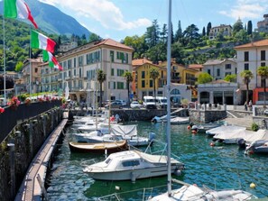 Boats docked in a picturesque marina surrounded by traditional Mediterranean-style buildings.