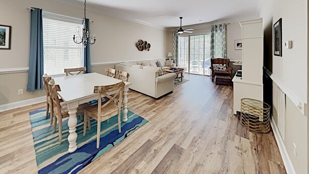 A spacious living area with a dining table, sofa, and a fireplace. - Tranquil Hideaway 4 Bdrm Condo in Avian Forest (Pawleys Island)