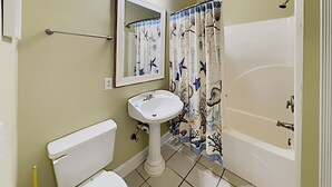 A bathroom with a toilet, sink, and bathtub. - Tranquil Hideaway 4 Bdrm Condo in Avian Forest (Pawleys Island)