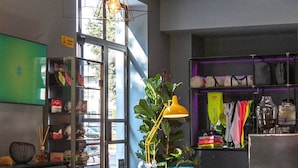 A modern cafe with a long wooden table, red chairs, and a large window. - Arryvo (Lecce)