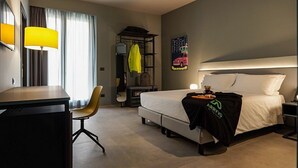 A hotel room with a bed, a desk, a chair, a wardrobe, and a poster on the wall. - Arryvo (Lecce)