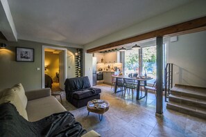 Un salon comprenant un canapé, une table basse et un coin repas avec des chaises et une table.