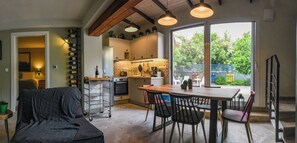 Une cuisine moderne avec un coin repas, de grandes fenêtres et un espace salon confortable.