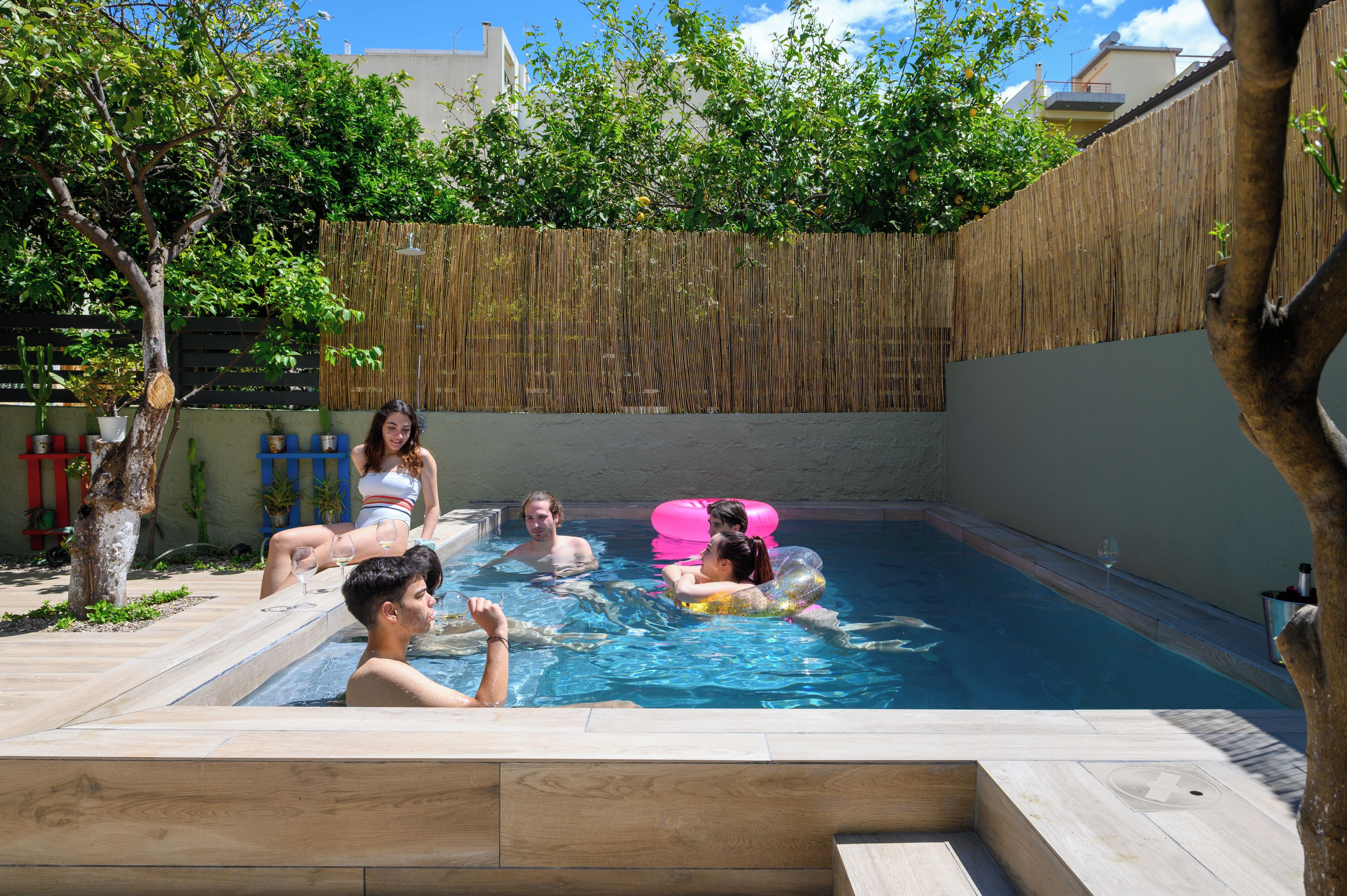 Una piscina con gente relajándose y flotando.