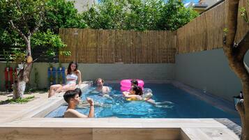 Una piscina con gente relajándose y flotando.