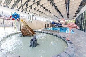 An indoor swimming pool with a dolphin sculpture, a flamingo sculpture, and a bird sculpture. - Spacious apartment near wellness (Maastricht)
