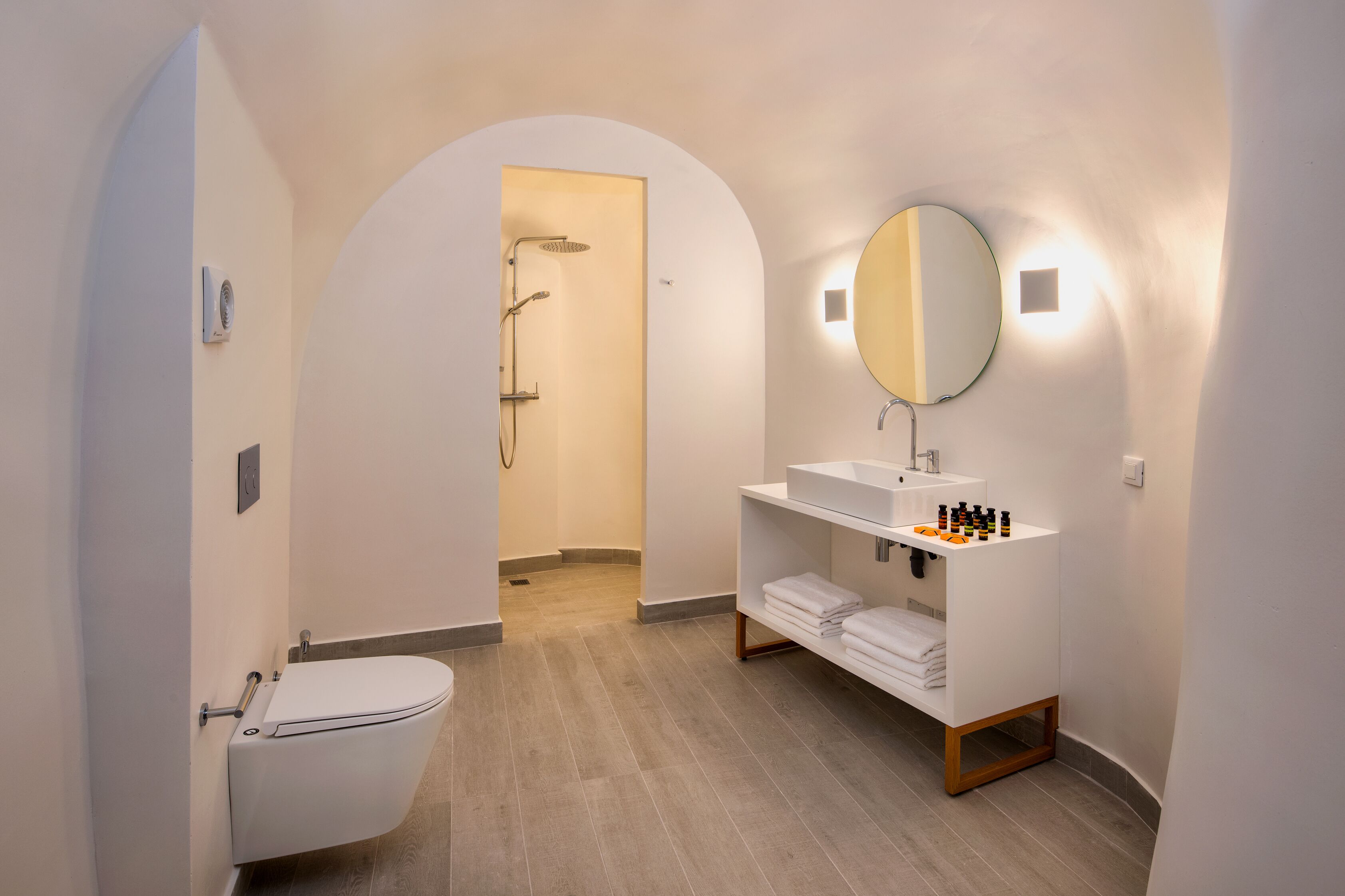 Un bagno moderno con WC, doccia e lavabo con specchio.