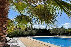 A swimming pool with palm trees and a stone wall. - Belvilla by OYO Cozy holiday home in Murcia (Moratalla)