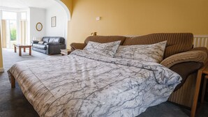 A bedroom with a large bed, a sofa, and a small table. - 6 Guests-free Public Parking-5 Min to Beach (Porthcawl)