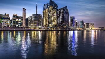A cityscape with modern buildings along a waterfront.