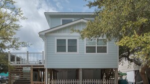 A two-story house with a front porch and a small deck. - 5136- Bayside Breeze - Soundside KDH Retreat | Dog-Friendly (Kill Devil Hills)