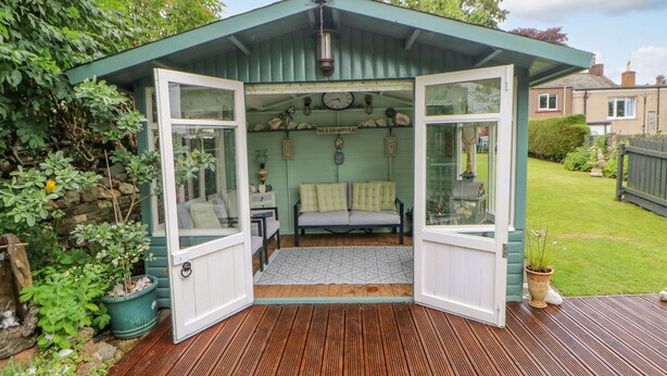 A cozy garden room with a bench, a clock, and a 'Welcome' sign. - Eden Cottage (Appleby-in-Westmorland)