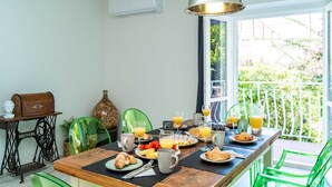 A breakfast table with plates of food, glasses of orange juice, and a coffee mug. - Apartment Raguseo (Dubrovnik)