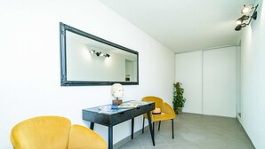 A modern room with a dining table, two yellow chairs, a black-framed mirror, and a potted plant. - Apartment Raguseo (Dubrovnik)