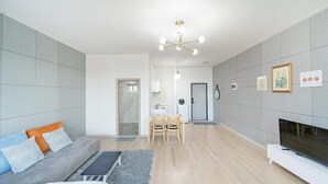 A modern living room with a sofa, TV, and dining area. - Yangyang In Memory Pension (Yangyang)