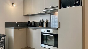 A modern kitchen with stainless steel appliances, a microwave, and a coffee maker.