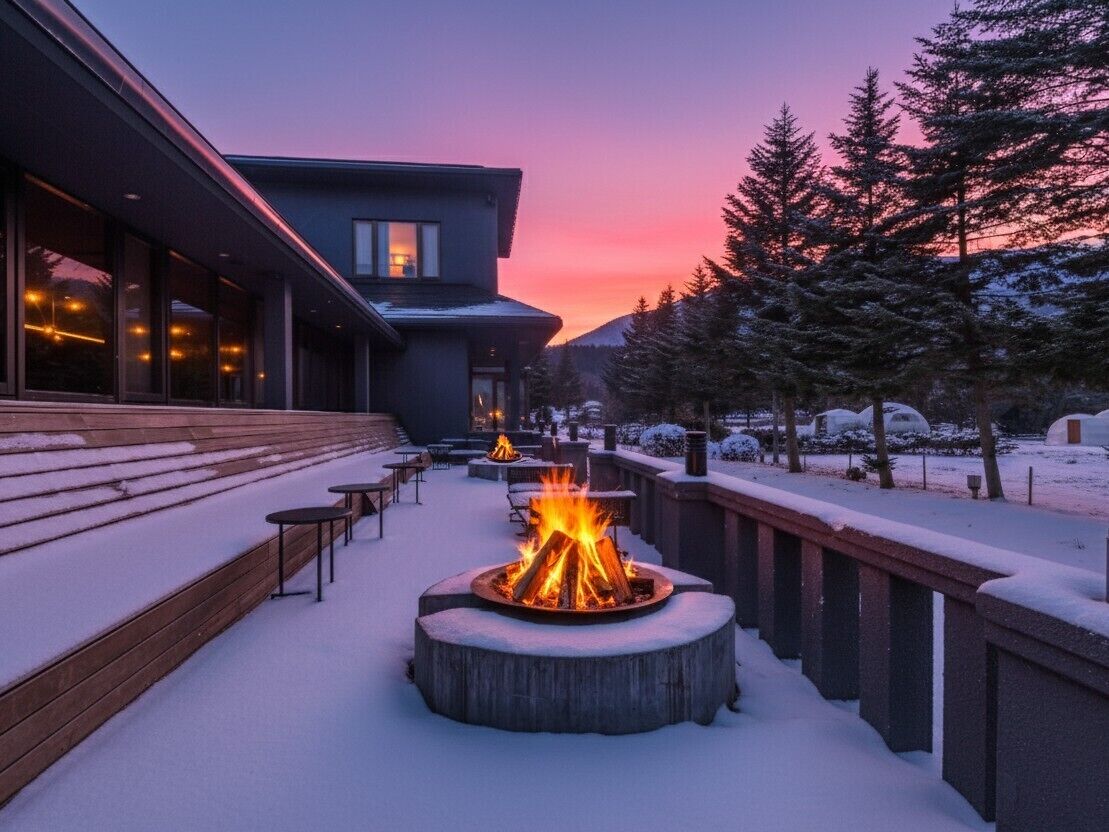 A snow-covered outdoor area with a fire pit and seating.