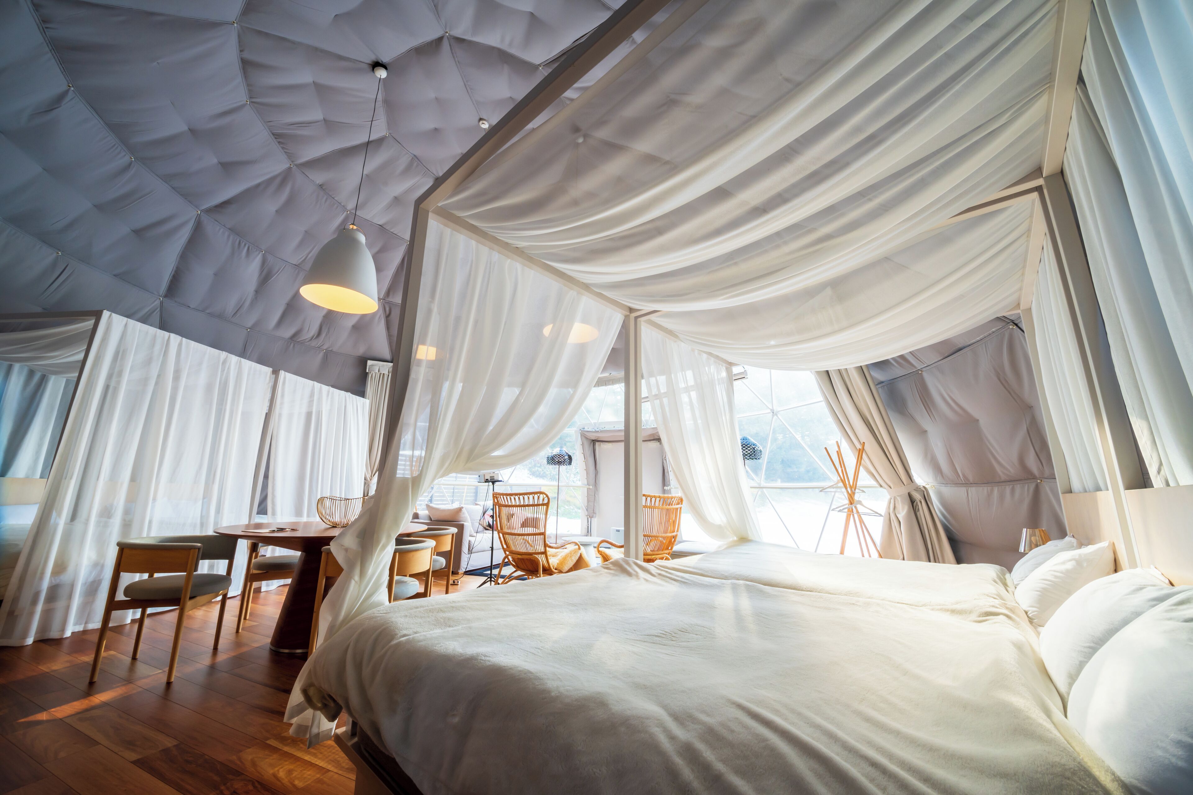 Ein geräumiges Schlafzimmer mit einem großen Bett, einem Essbereich und einer Sitzecke mit Stühlen.