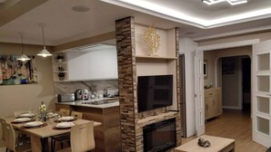 Una sala de estar moderna con chimenea, comedor y cocina.