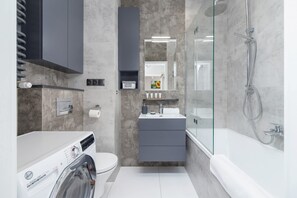 Bathtub, hair dryer, towels, shampoo