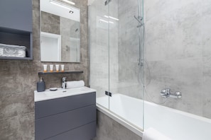 Bathtub, hair dryer, towels, shampoo
