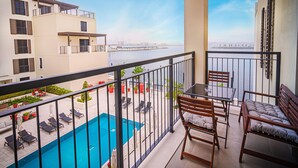 Ein Balkon mit Pool, Liegestühlen und einem Tisch.