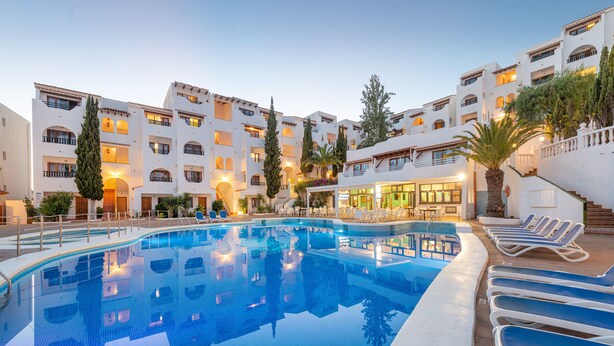 A hotel with a swimming pool, multiple balconies, and outdoor seating areas. - Holiday Park Santa Ponsa (Calvia)