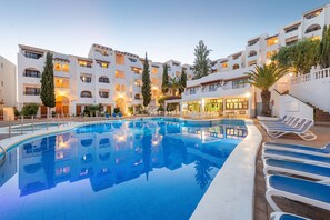 A hotel with a swimming pool, multiple balconies, and outdoor seating areas. - Holiday Park Santa Ponsa (Calvia)