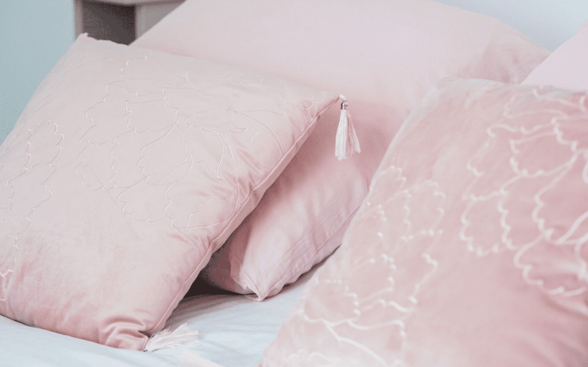 A bed with multiple pillows and a blanket.