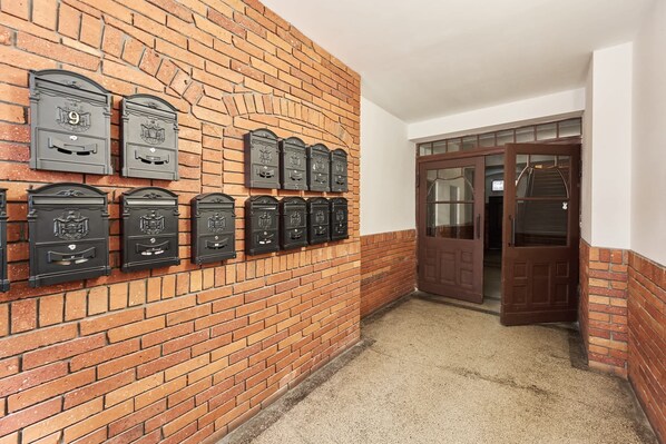 A hallway with a brick wall and mailboxes. - Elegant Apartment | 500 m to Market Square, City Center of Wroclaw (Wroclaw)