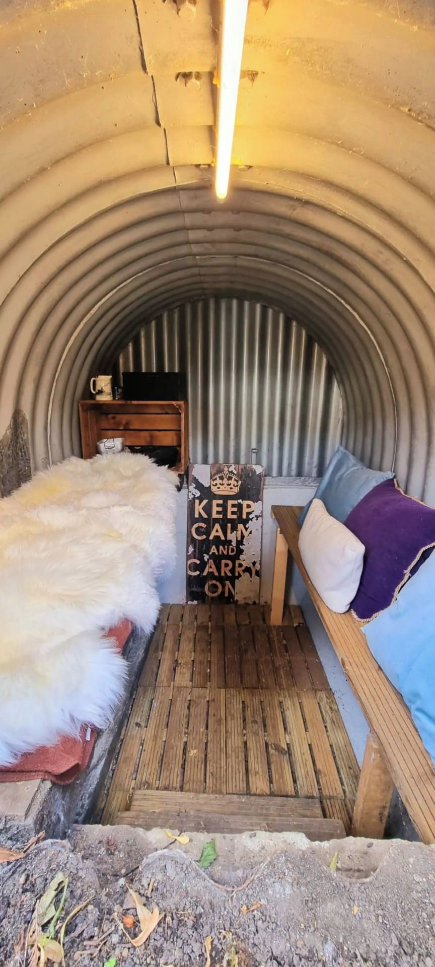 A cozy, enclosed space with a bed, a small table, and a bench.