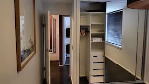 A narrow hallway with a closet on the right, a door leading to another room on the left, and a framed picture on the left wall. - Homely 1 Bedroom Retreat in South Yarra With Balcony (South Yarra)