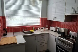 Departamento básico, 1 cama Queen size | Cocina privada | Refrigerador, parrilla de estufa, lavavajillas y tetera eléctrica 