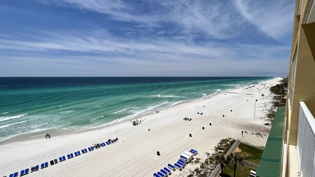 A beach view from a balcony with rows of blue chairs and a sandy beach. - 8th Floor - Unit 804 2BR 2BA - Beach Service INCLUDED!! (Master Walk-in Shower) (Panama City Beach)