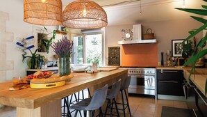 Een moderne keuken met een houten kookeiland, barstoelen en een groot raam.
