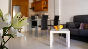 Un soggiorno moderno con un divano, un tavolino da caffè e un'area pranzo sullo sfondo.