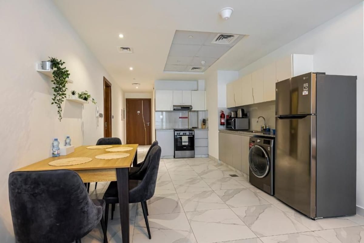 Cocina compacta con refrigerador, horno, microondas y lavadora.