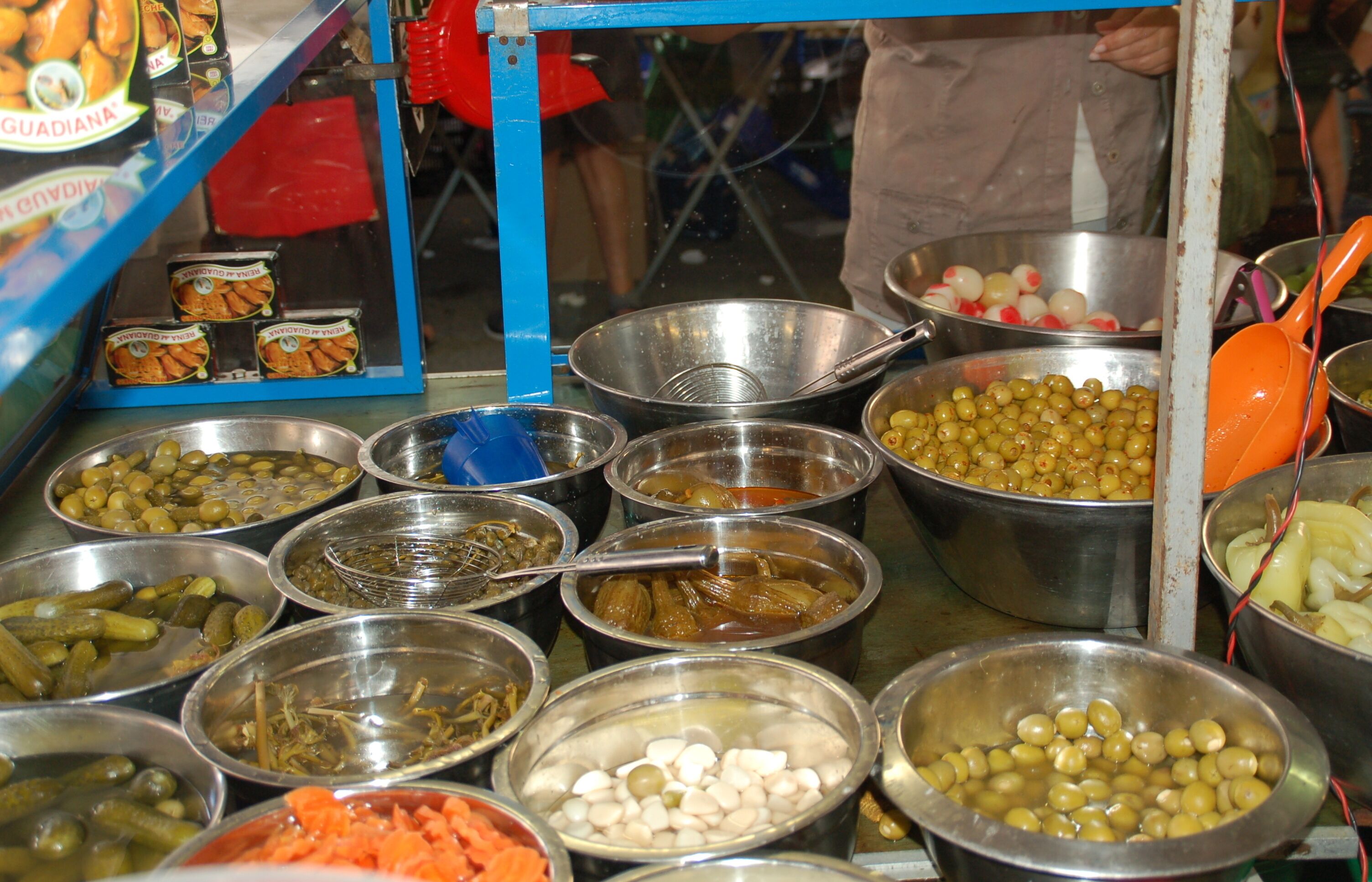 A variety of food items displayed in metal bowls at a food stall.