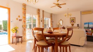 Un coin repas avec une table ronde, des chaises et un ventilateur de plafond.